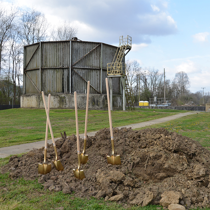Groundbreaking-Andrews-WWTP-Modernization. Picture of golden shovels in mound of dirt next to treatment plant