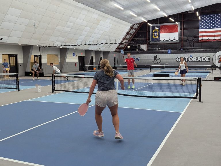 Interns playing pickleball at an indoor pickleball court
