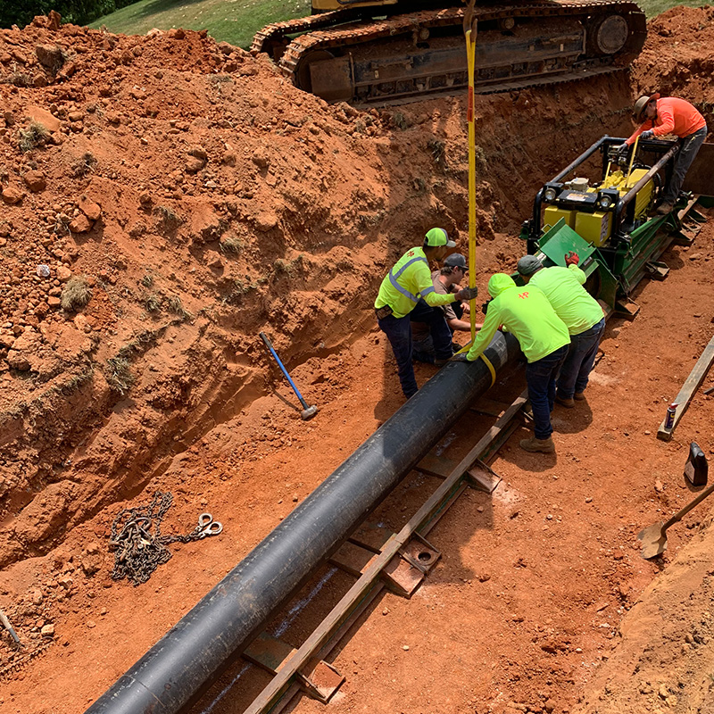 Regionalization via water interconnect. Workmen installing water line by directional drilling.
